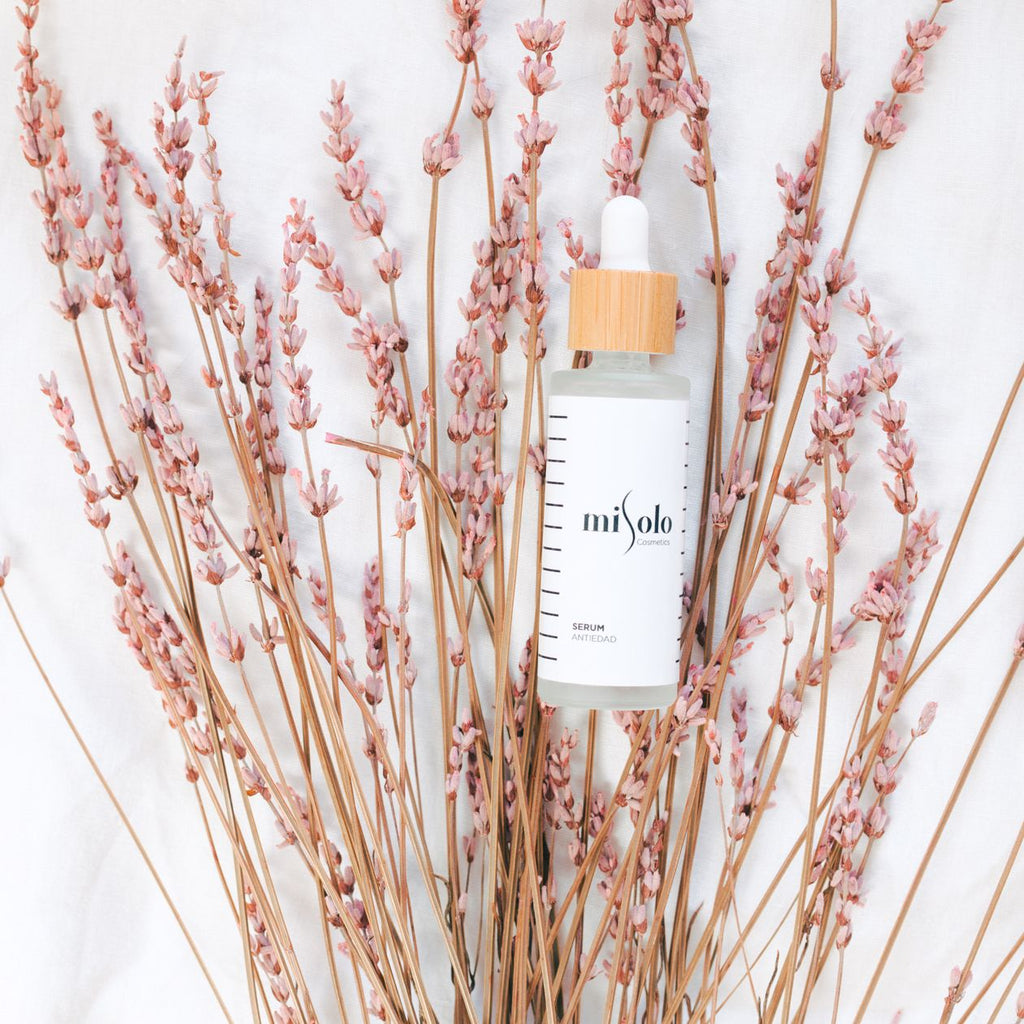 LumaLift serum bottle with dropper styled with pink flowers